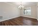 Charming dining room with hardwood floors, large window, and elegant chandelier at 6375 Haystack Ct, Cumming, GA 30040