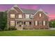 Stunning brick home with black shutters and a well-manicured lawn at dusk at 6375 Haystack Ct, Cumming, GA 30040