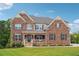 Charming two-story brick home featuring a covered porch and meticulously manicured lawn at 6375 Haystack Ct, Cumming, GA 30040
