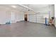 Spacious garage area with epoxy flooring, automatic garage door, and ample space for multiple cars at 6375 Haystack Ct, Cumming, GA 30040
