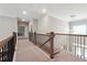 Upstairs hallway features carpet flooring, wood and metal banister, and spiral light fixture at 6375 Haystack Ct, Cumming, GA 30040