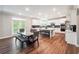 Spacious kitchen with white cabinets, stainless steel appliances, a large island, and wood-look flooring at 6375 Haystack Ct, Cumming, GA 30040