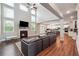 Open-concept living room with a fireplace and tall windows, seamlessly connecting to the kitchen at 6375 Haystack Ct, Cumming, GA 30040