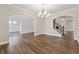 Open living area featuring hardwood floors, decorative lighting, and view to stairs at 6375 Haystack Ct, Cumming, GA 30040