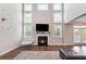 Bright living room with fireplace, tall windows, and modern decor creates a welcoming space at 6375 Haystack Ct, Cumming, GA 30040