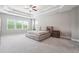 Serene primary bedroom with tray ceilings, plush carpeting, and large windows at 6375 Haystack Ct, Cumming, GA 30040