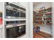 Walk-in pantry features organized shelving and modern, built-in stainless-steel appliances at 6375 Haystack Ct, Cumming, GA 30040