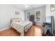 Comfortable bedroom with wood floors, large bed, dresser, and natural light from two windows at 100 Inspiration Ln, Dallas, GA 30157