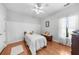 Bright bedroom features hardwood floors, white ceiling fan, and large window with natural light at 100 Inspiration Ln, Dallas, GA 30157