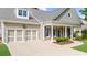 Inviting home exterior featuring a covered front porch, lush lawn, and two-car garage at 100 Inspiration Ln, Dallas, GA 30157