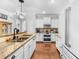Bright, white kitchen with stainless steel appliances, granite counters, and hardwood floors at 100 Inspiration Ln, Dallas, GA 30157