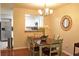 Cozy dining area with table, four chairs, wicker mirror, and decorative chandelier near a kitchen at 1676 Northridge Dr, Morrow, GA 30260