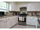 Bright kitchen featuring white cabinets, modern appliances, and granite countertops at 1676 Northridge Dr, Morrow, GA 30260