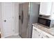 Kitchen featuring stainless steel refrigerator, microwave, and white cabinets with granite countertops at 1676 Northridge Dr, Morrow, GA 30260