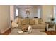 Cozy living room with hardwood floors, a large sofa, and decoratively pillows near dining area at 1676 Northridge Dr, Morrow, GA 30260