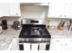 Stainless steel range with white cabinets and granite counters in a well-equipped kitchen at 1676 Northridge Dr, Morrow, GA 30260