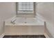Corner bathtub with marble-look floors and a window above at 1922 Knipe Sw Dr, Marietta, GA 30064