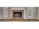 Close up of brick fireplace with white trim and wood flooring in the living room, with windows on either side at 1922 Knipe Sw Dr, Marietta, GA 30064
