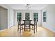 Charming dining area features a round table set beneath a modern light fixture and three windows offering natural light at 1314 Durham Ter, Mcdonough, GA 30252