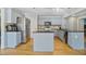Well-equipped kitchen features gray cabinets, a functional island, stainless steel appliances, and hardwood flooring at 1314 Durham Ter, Mcdonough, GA 30252