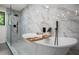 Freestanding soaking tub and glass enclosed shower with marble tiling in modern bathroom at 1749 Ridge Valley Nw Ct, Atlanta, GA 30327