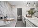 Bright bathroom with a soaking tub, dual sink vanity, and marble style tile at 1749 Ridge Valley Nw Ct, Atlanta, GA 30327