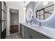 Modern bathroom featuring dual sinks, gray cabinets, and illuminated round mirrors at 1749 Ridge Valley Nw Ct, Atlanta, GA 30327