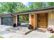 Charming home featuring modern wood and glass door, stone accents, and a black multi-paneled garage door at 1749 Ridge Valley Nw Ct, Atlanta, GA 30327