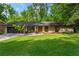 Charming ranch-style home boasts a lush green lawn, modern windows, and an attached two-car garage at 1749 Ridge Valley Nw Ct, Atlanta, GA 30327