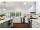 Bright kitchen with white cabinets, modern appliances, marble countertops, and a farmhouse sink at 1749 Ridge Valley Nw Ct, Atlanta, GA 30327