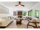 Bright living room with fireplace, white sofa, two chairs, and a ceiling fan at 1749 Ridge Valley Nw Ct, Atlanta, GA 30327