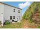 Backyard featuring a small patio with grill and seating, with a grassy area and hillside at 302 Braswell Ct, Woodstock, GA 30188