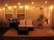 Back patio with seating and a grill, lit by string lights for evening enjoyment at 302 Braswell Ct, Woodstock, GA 30188