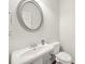 Powder room with sink, toilet, silver mirror, and wood-look floor at 302 Braswell Ct, Woodstock, GA 30188