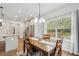 Dining room features a view to the back yard, open to the kitchen, and modern light fixture at 302 Braswell Ct, Woodstock, GA 30188