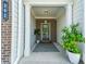 Inviting front porch with classic columns, brick accents, and a welcoming striped rug, enhancing curb appeal at 302 Braswell Ct, Woodstock, GA 30188