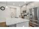 This kitchen boasts an oversized granite island, stainless steel appliances, and lots of counter space at 302 Braswell Ct, Woodstock, GA 30188