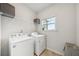 Bright laundry room with washer, dryer, and open shelving at 302 Braswell Ct, Woodstock, GA 30188