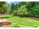Beautiful backyard featuring a lush lawn, mature trees, and landscape-stone bordered flower beds at 3052 Fleet Sw St, Marietta, GA 30064