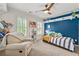 Stylized bedroom featuring a blue accent wall, white trim, and natural light at 3052 Fleet Sw St, Marietta, GA 30064
