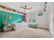 Bright bedroom featuring turquoise accent wall, neutral carpet, ceiling fan, and windows at 3052 Fleet Sw St, Marietta, GA 30064