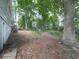 Expansive backyard bordered by mature trees with a glimpse of a wooden deck at 712 Copper Trace Way, Woodstock, GA 30189