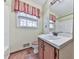 Bathroom features a sink, mirror, red valance, and toilet at 712 Copper Trace Way, Woodstock, GA 30189