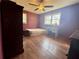 Bedroom with laminate flooring, ceiling fan, window, desk, and closet at 712 Copper Trace Way, Woodstock, GA 30189