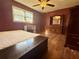 Bedroom with laminate flooring, ceiling fan, bed, desk, and closet at 712 Copper Trace Way, Woodstock, GA 30189