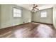 Spacious bedroom featuring hardwood floors, ceiling fan, and two windows for natural light at 712 Copper Trace Way, Woodstock, GA 30189