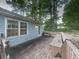 Wooden deck with seating, and a view to the side yard and surrounding trees at 712 Copper Trace Way, Woodstock, GA 30189