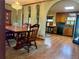 Open layout featuring dining room and kitchen with wood cabinets, arched entryways, and natural light at 712 Copper Trace Way, Woodstock, GA 30189
