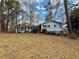 Charming home features a well-maintained lawn, mature trees, and blue siding at 712 Copper Trace Way, Woodstock, GA 30189