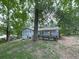 Back exterior of home showing the wood deck, and a lush backyard with mature trees at 712 Copper Trace Way, Woodstock, GA 30189